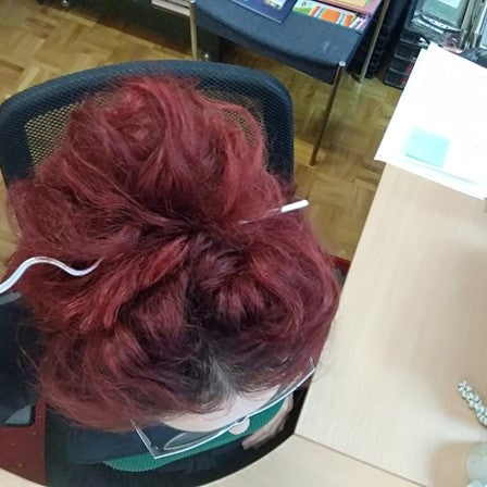 vrouw met opgestoken haar met kronkelende haarspeld in zilver