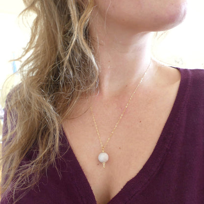 vrouw met handgemaakte lichtroze bal ketting van aquamarijn edelsteen 10 mm en gouden puntje in gold filled