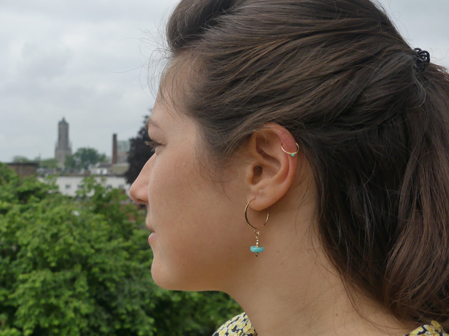 vrouw met fairmined oorbellen van gehamerd gold filled en amazoniet stenen