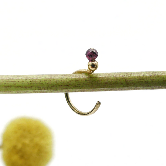 duurzame handgemaakte oorpiercing met granaat steentje en gouden knopje