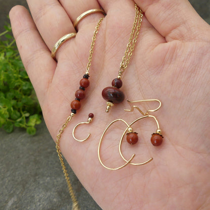 luxe handgemaakte sieraden set met rode jaspis en goud, met oorklimmer oorknuffels pendel en armband