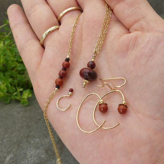 luxe handgemaakte sieraden set met rode jaspis en goud, met oorklimmer oorknuffels pendel en armband